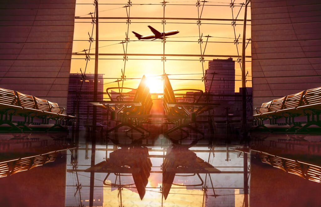 A plane is flying over a city at sunset
