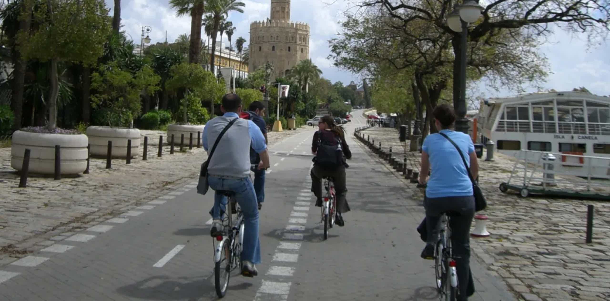 Imagen de recurso de varias personas paseando por Sevilla en bicicleta.