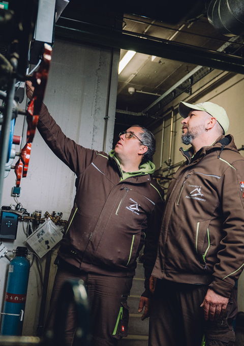 Mitarbeiter von Francesco's Hausmeisterservice bei technischen Wartungsarbeiten in einem Heizungsraum