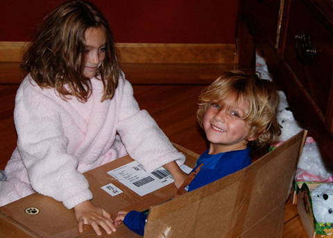 2 kids in a cardboard box