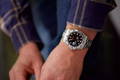 Man tying his shoes wearing a Rolex Explorer 2