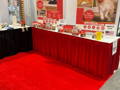 two poly knit table skirts, one red and one black on two tables at a trade show
