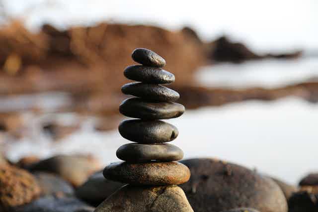 Stacked rocks beside a serene lake
