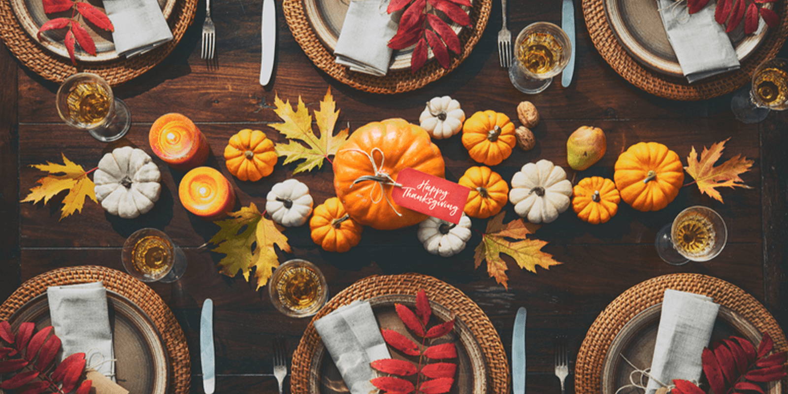 Fall table setting decorated with pumpkins and leaves.