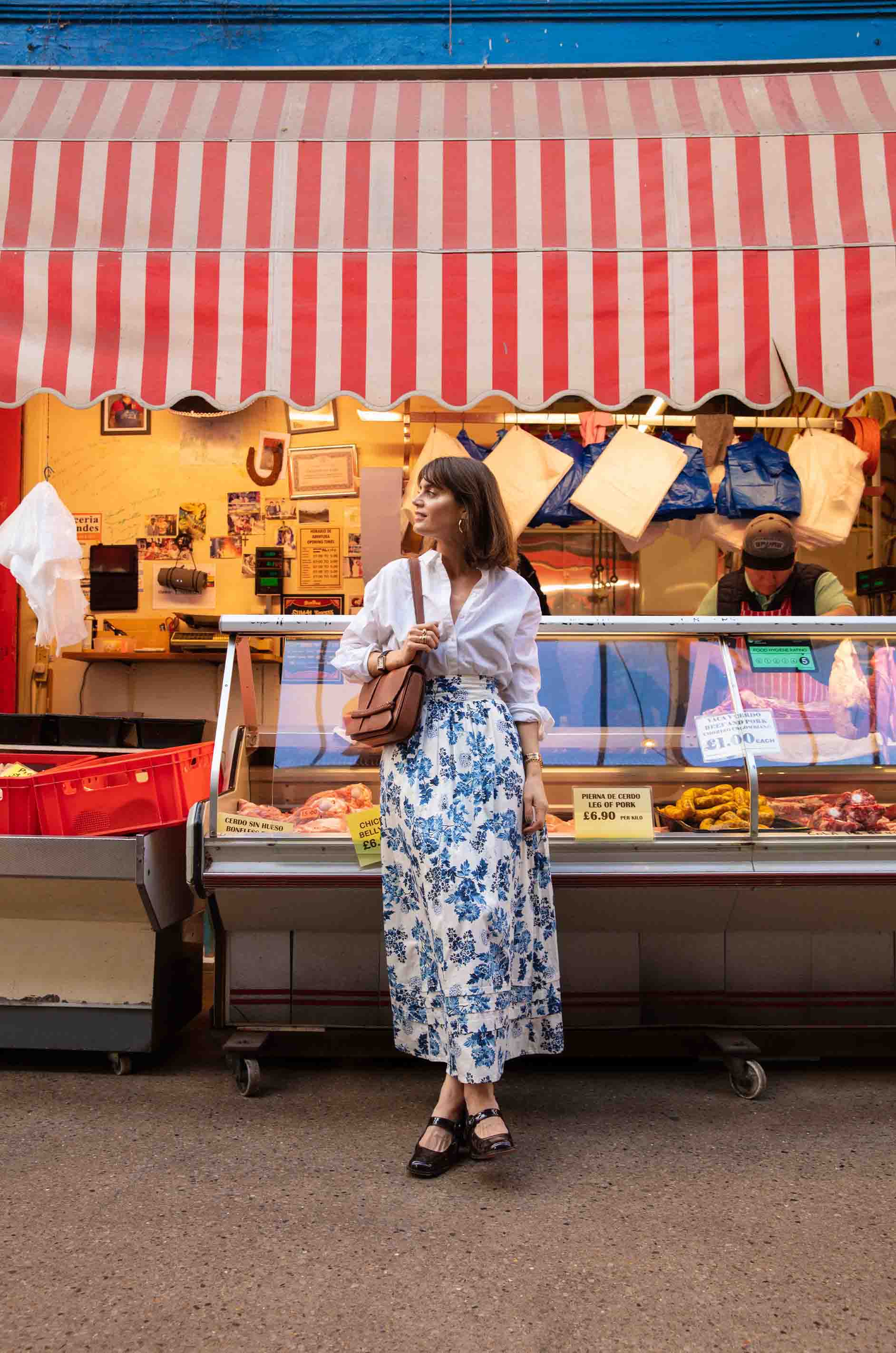 Sarah Corbett-Winder stands in front of a market stall in YOLKE Cotton Prairie Skirt