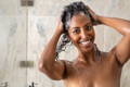 Latin american woman smiling and holding healthy frizz-free hair in hands