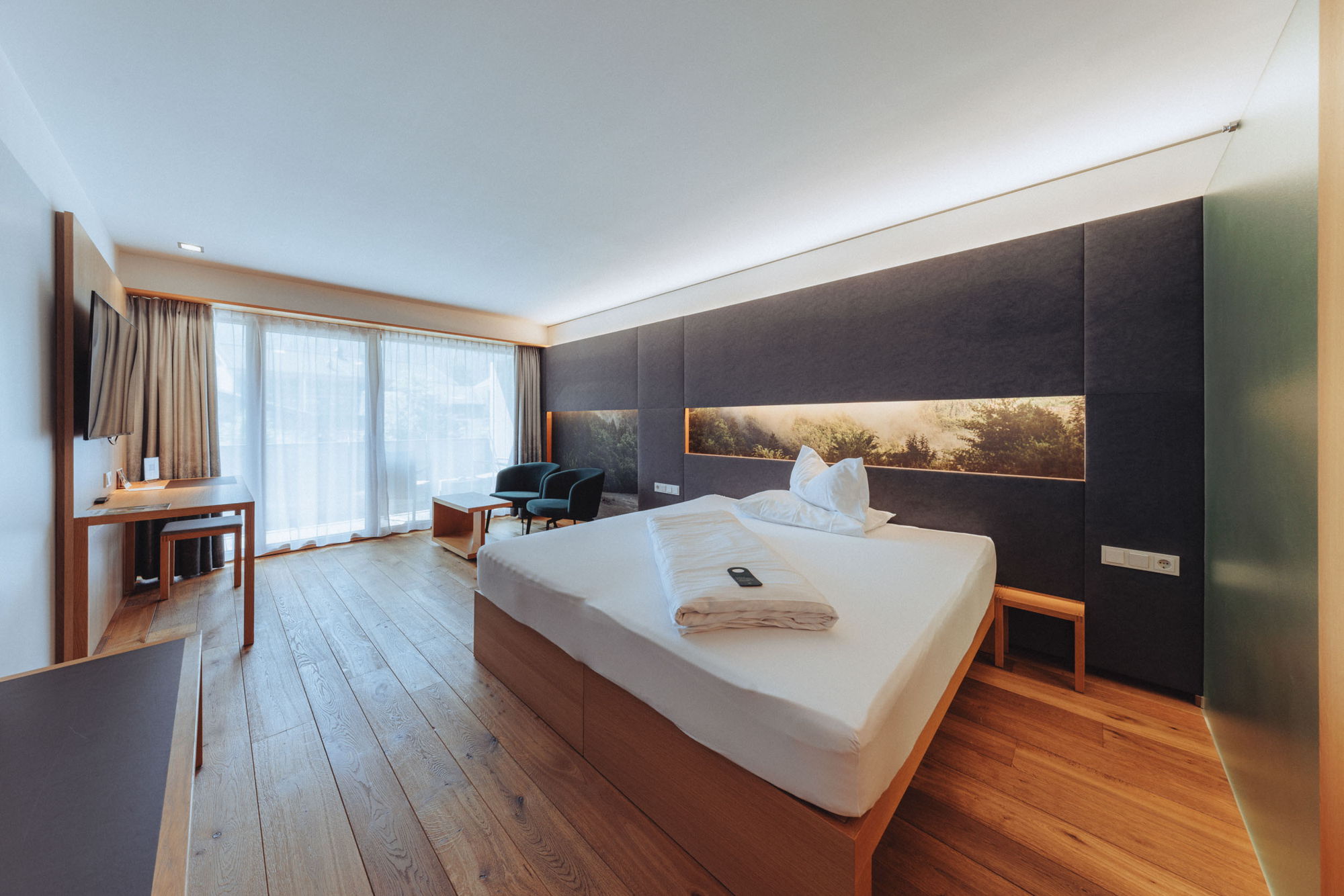 Doppelbett und Wohnbereich im Zimmer Kanisfluh in Mellau