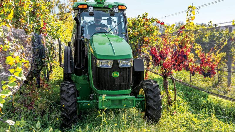 person in john deere tractor in field