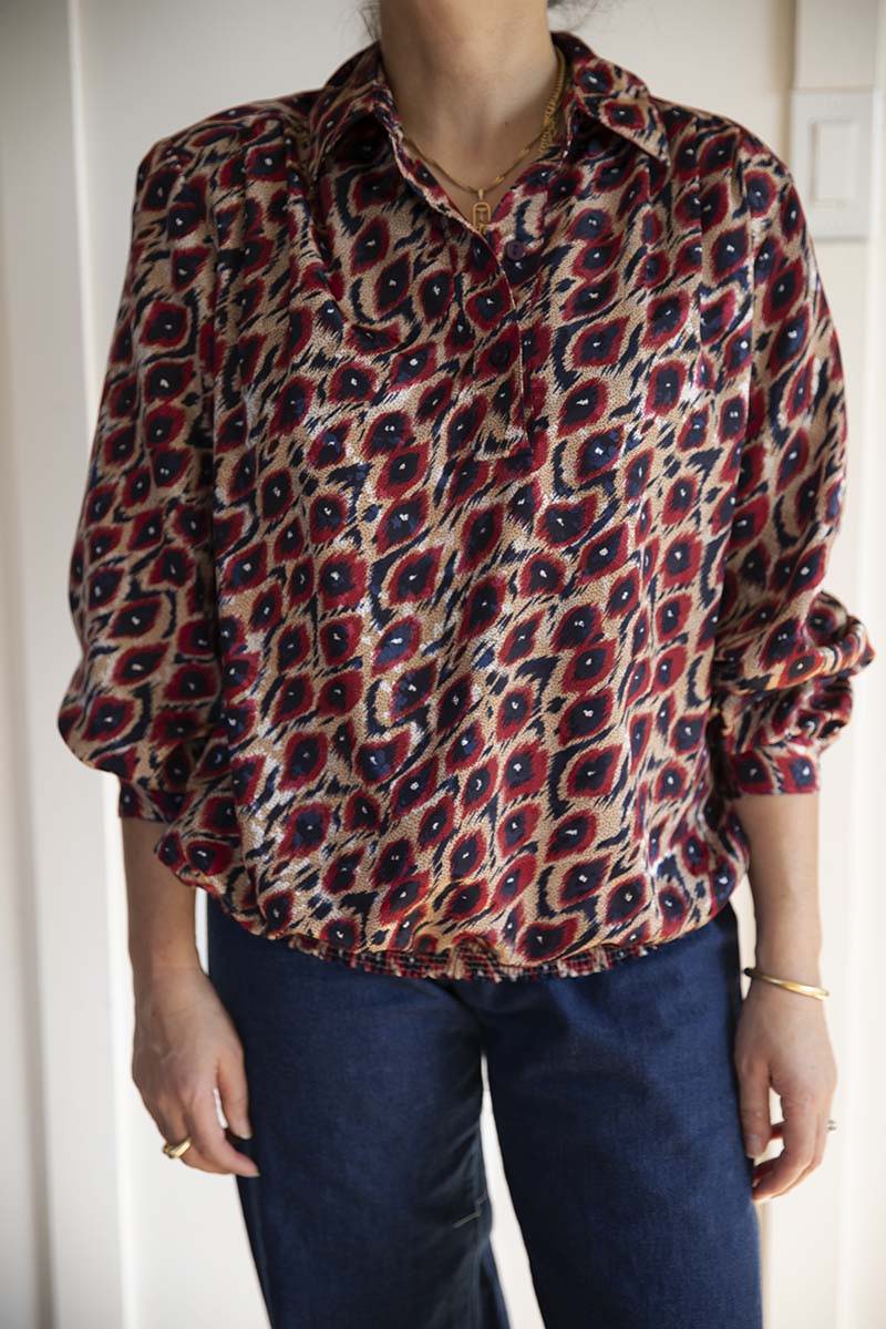 80s pop over print silky blouse red, blue and cream. Has an elastic waistband, button up collar and long sleeves. Mindfully sourced for Cura Found in Seattle, Washington.