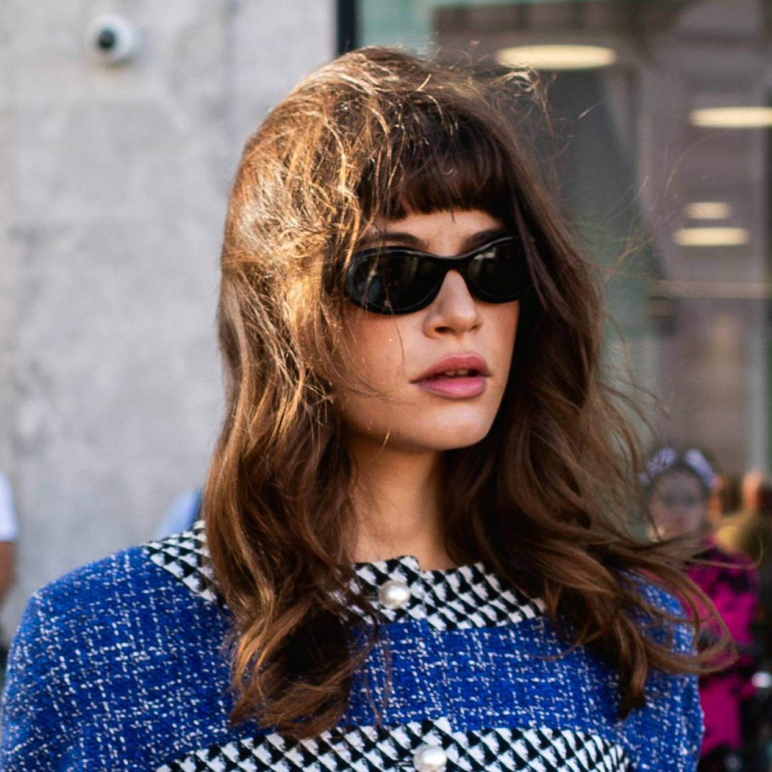 woman with brown hair and bangs wearing sunglasses