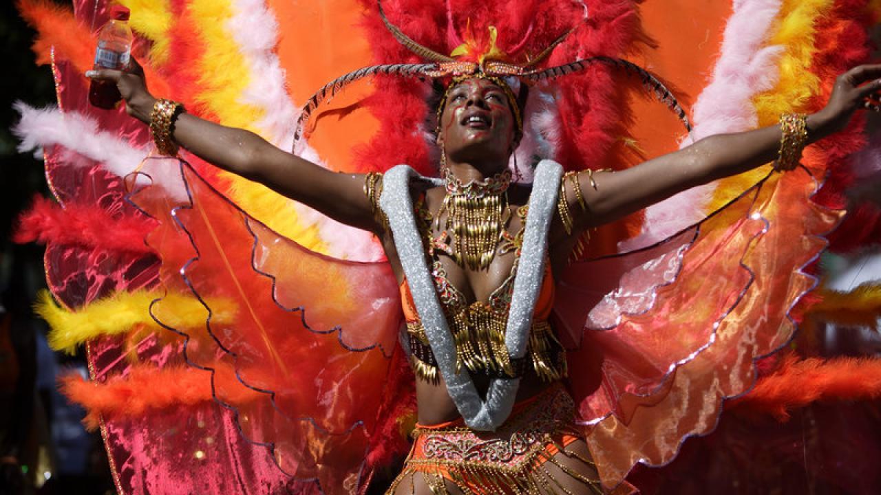 A woman wears a dramatic orange, red and yellow feathered costume