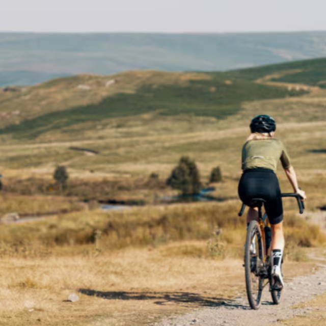 A woman riding an e-Bike on gravel