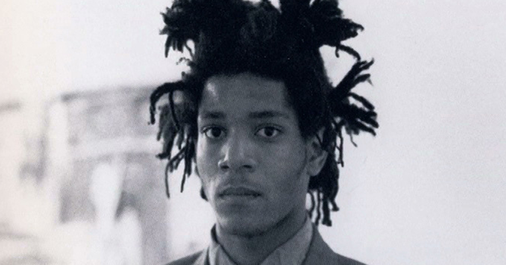 A young Basquiat with a serious expression looking forward.