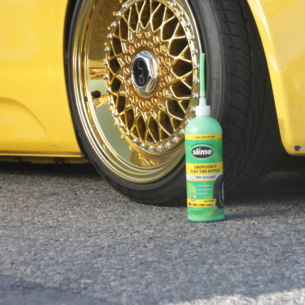 Slime Emergency Tire Repair Sealant in Front of Fancy Car