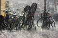 Des vélos garés en centre-ville sous la pluie