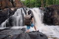 man standing on a rock in front of a waterfall wearing an isle royale pack