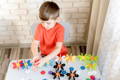 Child using a Montessori activity board to sort and arrange colorful pieces