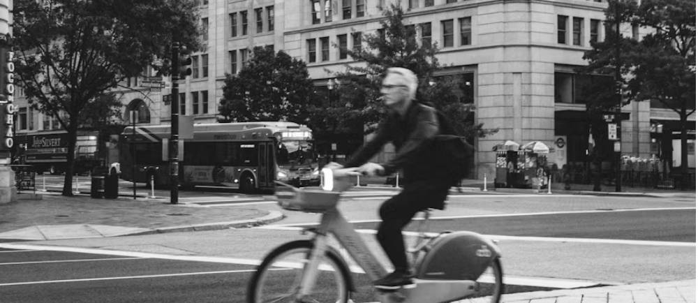 man riding a city bike through the street
