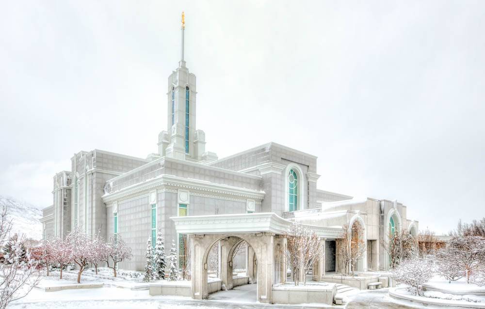 Angled photo of the Mount Timpanogos Temple, showing the archways covered in snow. 