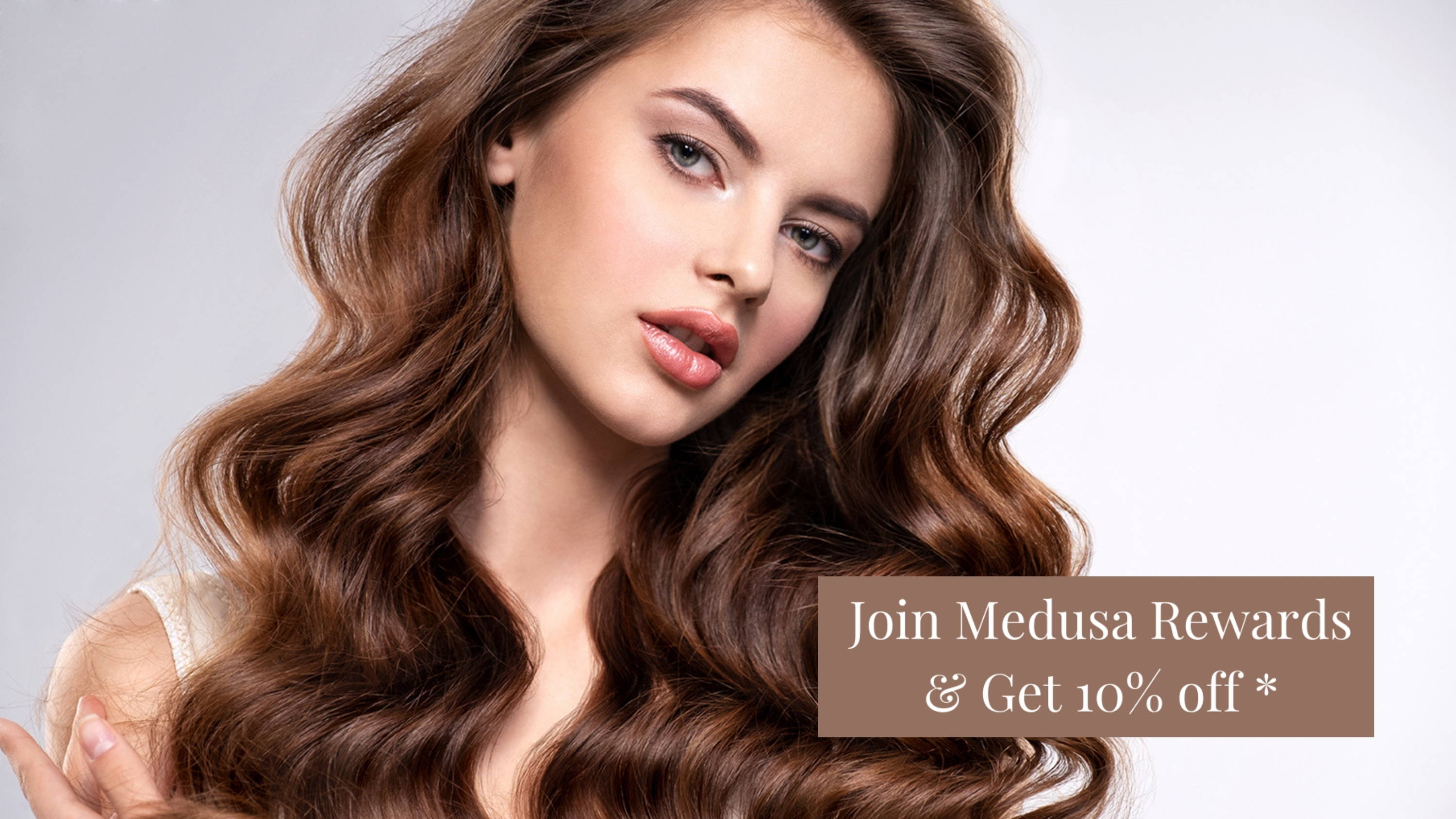 Sign that says Join Medusa Rewards and Get 10% off is positioned over an image of a young woman wearing wavy brown Medusa hair extensions 