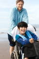 Father-on-beach-with-disabled-son-in-wheelchair