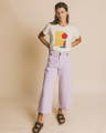 Woman wearing printed organic cotton t-shirt and soft lilac sustainable trousers from Spanish sustainable clothing brand, Thinking Mu.