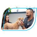 Image of veterinarian Dr. James Bascharon in a vet clinic treating a small dog with a fellow veterinarian.