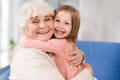 Grandmother and granddaughter hugging and smiling.