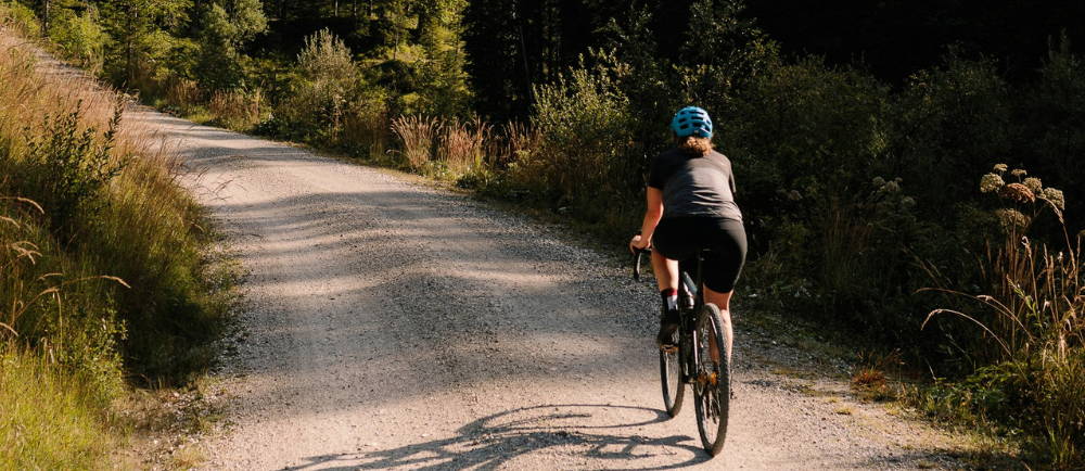A woman riding an electric road/gravel bike in the mountains