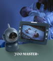 mother holding a sleeping baby in a dark room with dim lighting with a babymoov yoo master video monitor in the front
