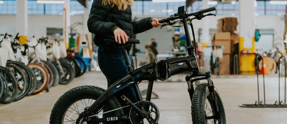Rider folding Aventon Sinch e-Bike in half
