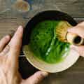 Matcha Green Tea being whisked with bamboo whisked