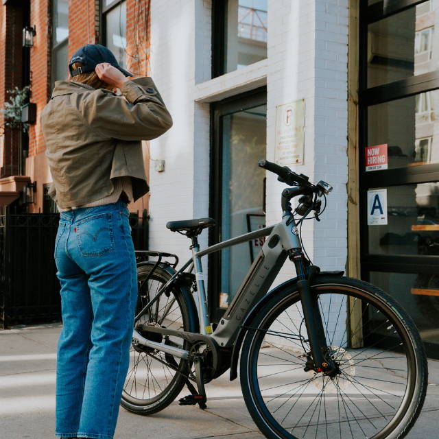 A woman standing next to a Gazelle Ultimate C380+ electric city bike