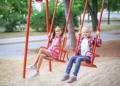 Two girls swinging from a swing