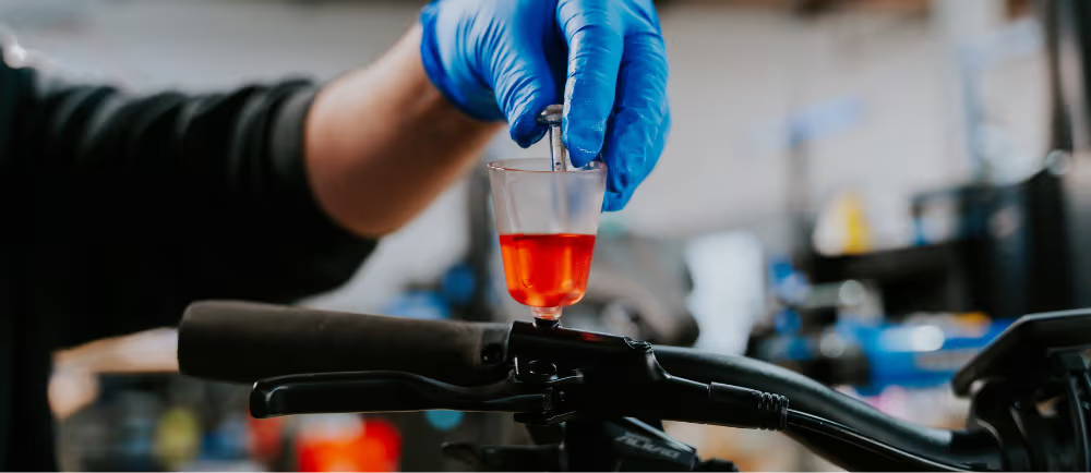a mechanic with brake fluid and a bike
