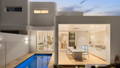 Havit outdoor wall lights and downlights illuminating a modern home exterior at dusk with pool and open-plan living beyond.