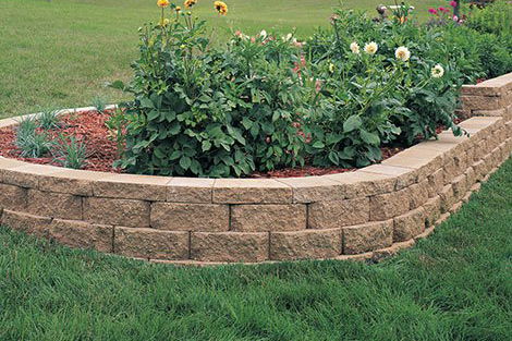Raised flower bed with a retaining wall that is capped with Windsor Wall Caps