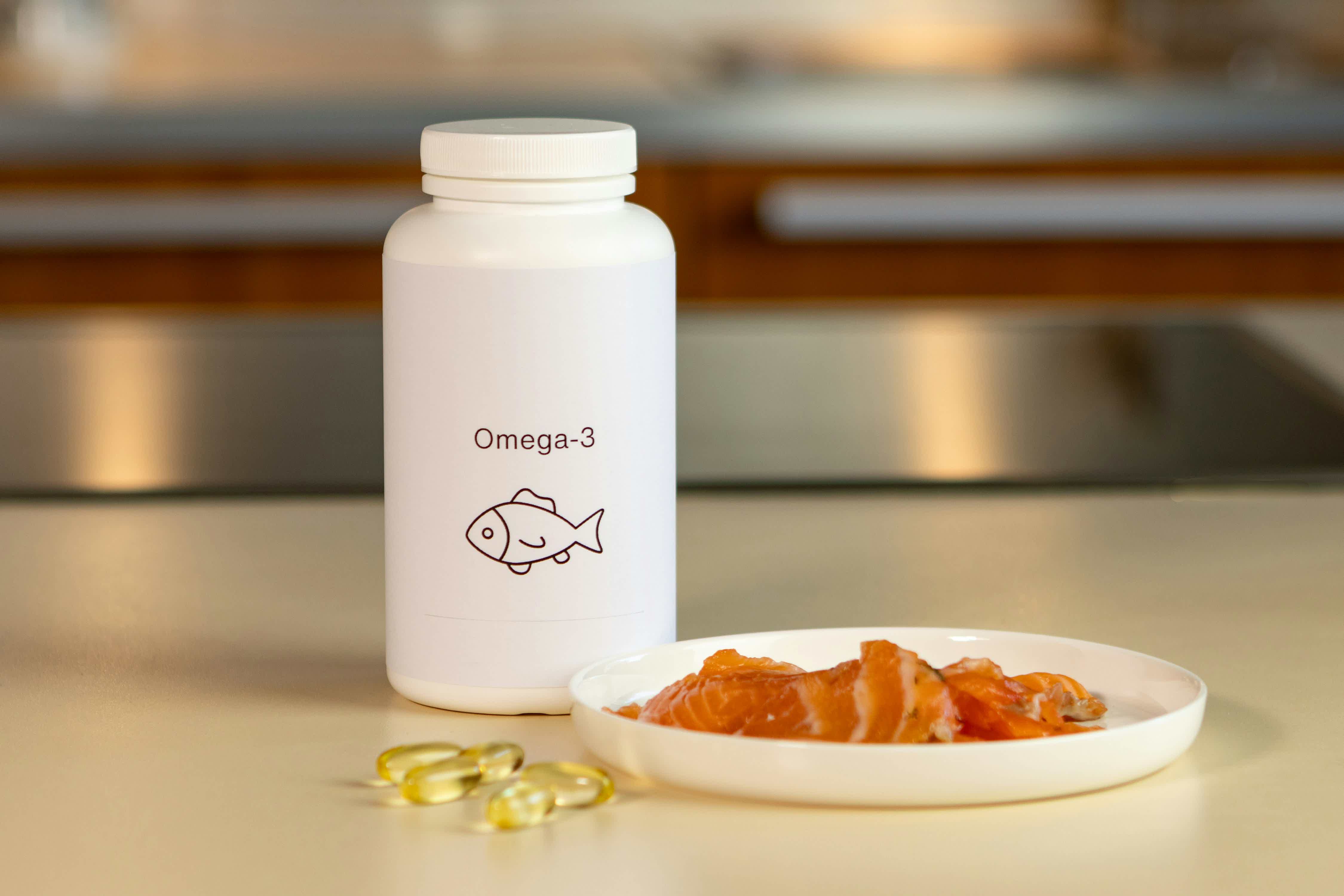a-bowl-of-fish-next-to-a-bottle-of-vitamins-rCAJjRuTHyE