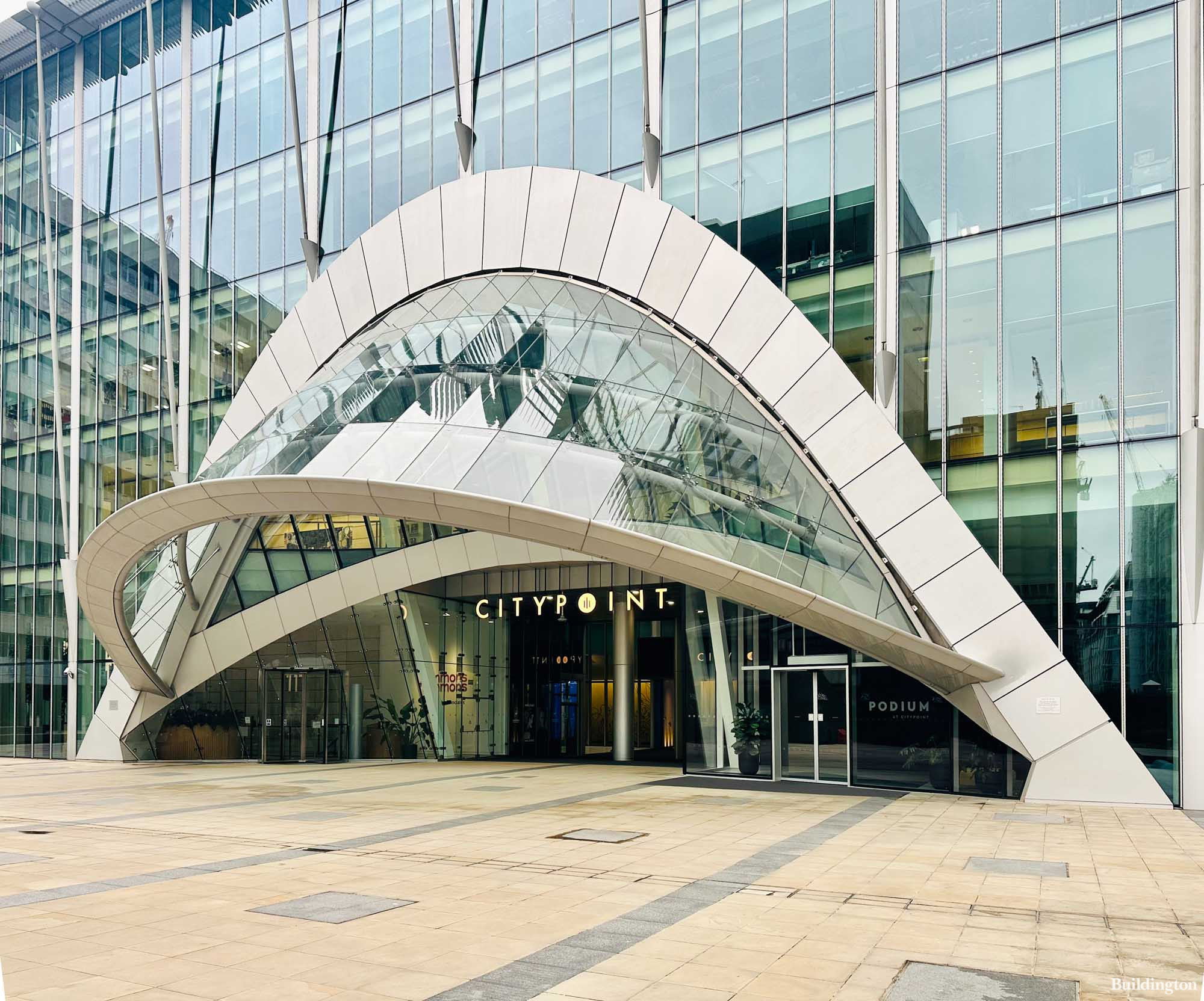 The image shows the modern glass entrance of CityPoint, a commercial building. The entrance features a distinctive curved white arch and a sign reading CITYPOINT above the doors.