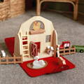 Close up on the Montessori Traveling Farm toy featuring farm-themed wooden figurines and a farm that transforms into a bag when closed. 