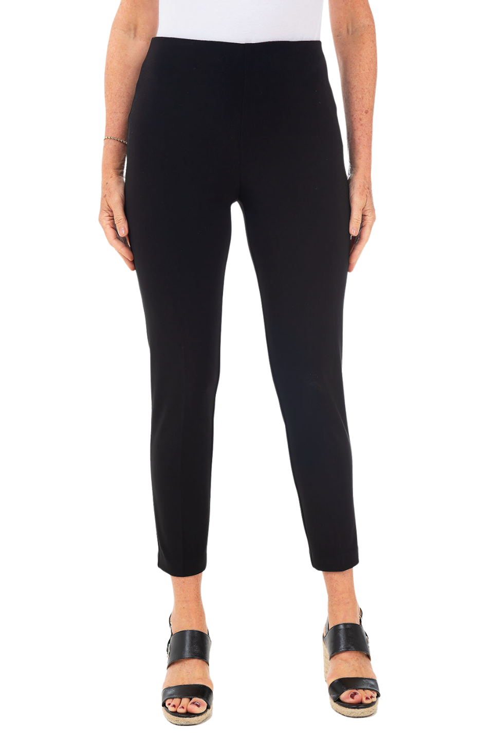 A woman wearing a black pant against a pink background