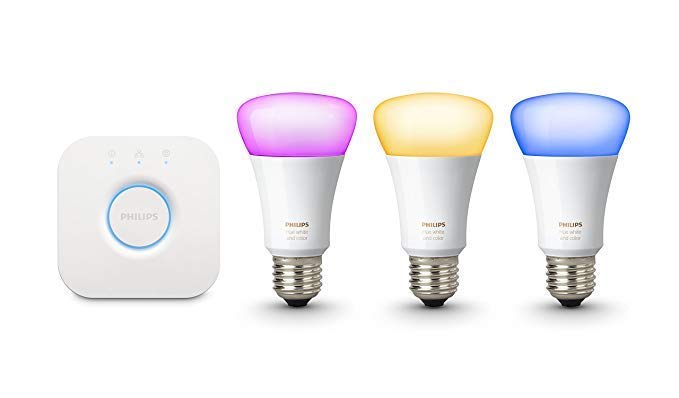 Phillips Hue smart hub next to three Phillips Hue smart coloured bulbs