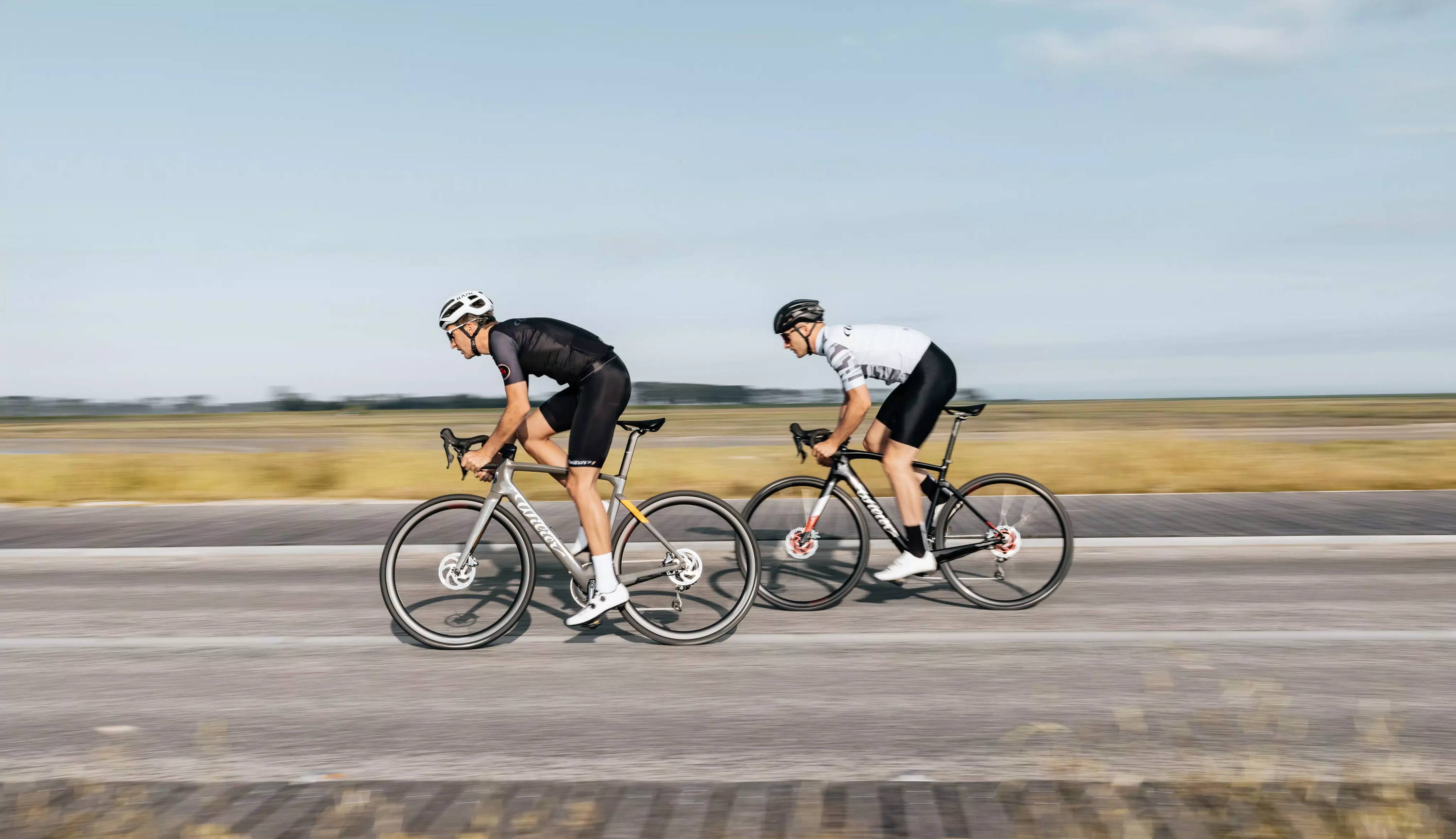 Duo de cyclistes en plein sprint sur leurs vélos électriques de route. 