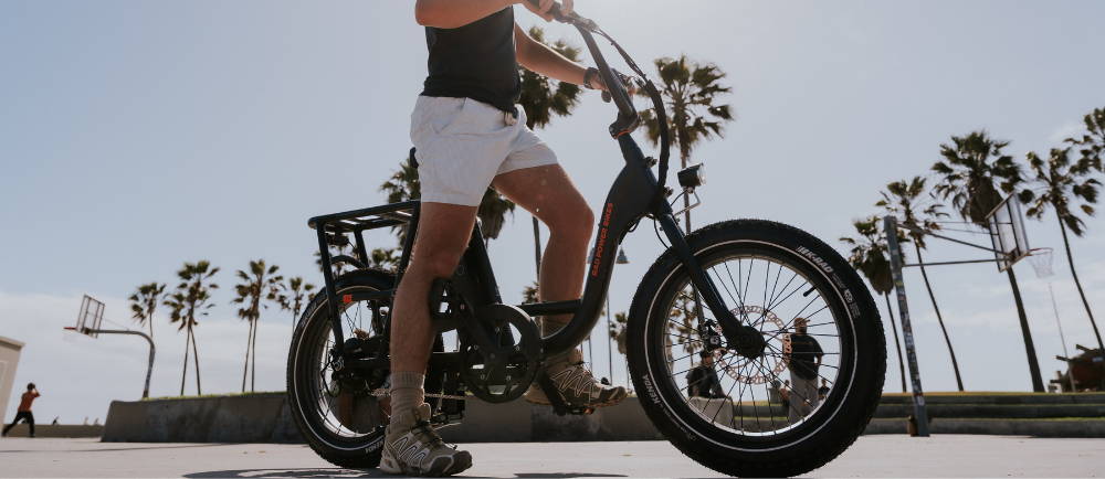 Rider on TadRunner 2 electric bike near beach and palm trees