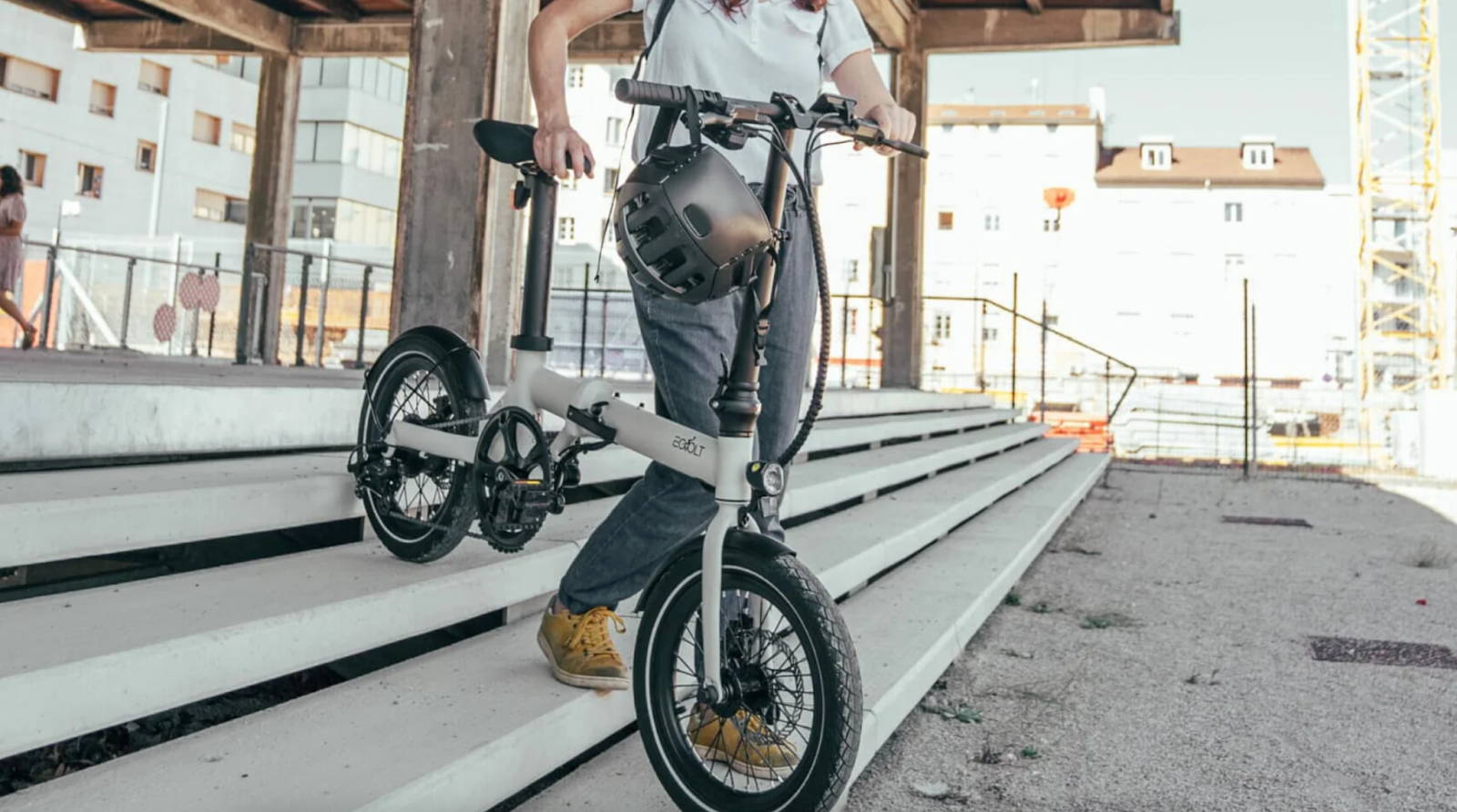 Une femme se rend au travail avec son vélo électrique pliable Eovolt Afternoon acheté dans la boutique ShiftBikes à Paris 11
