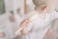 Baby holding a pink/white rattle toy.