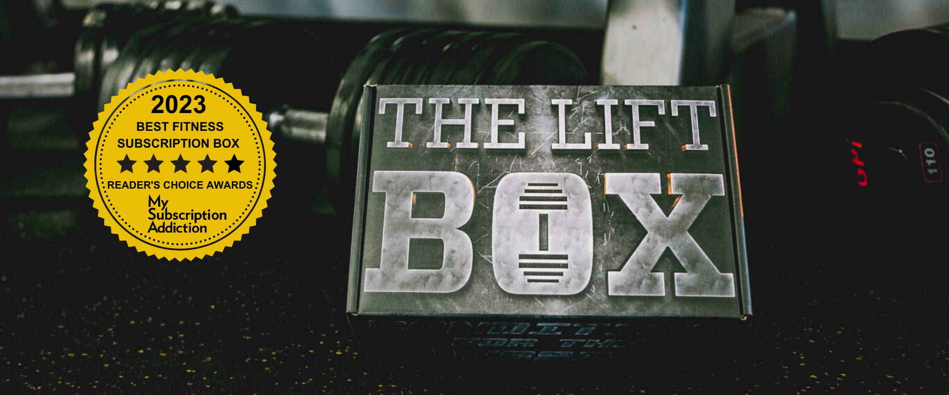 The Lift Box subscription box resting against workout equipment with a yellow award badge from My Subscription Addiction.