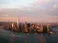 Panoramablick auf die Skyline der Stadt bei Sonnenuntergang, in der sich das goldene Licht auf den hohen Gebäuden und dem Fluss spiegelt.