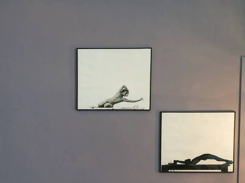 Framed photos of a young Marjorie Oron on the Pilates Reformer
