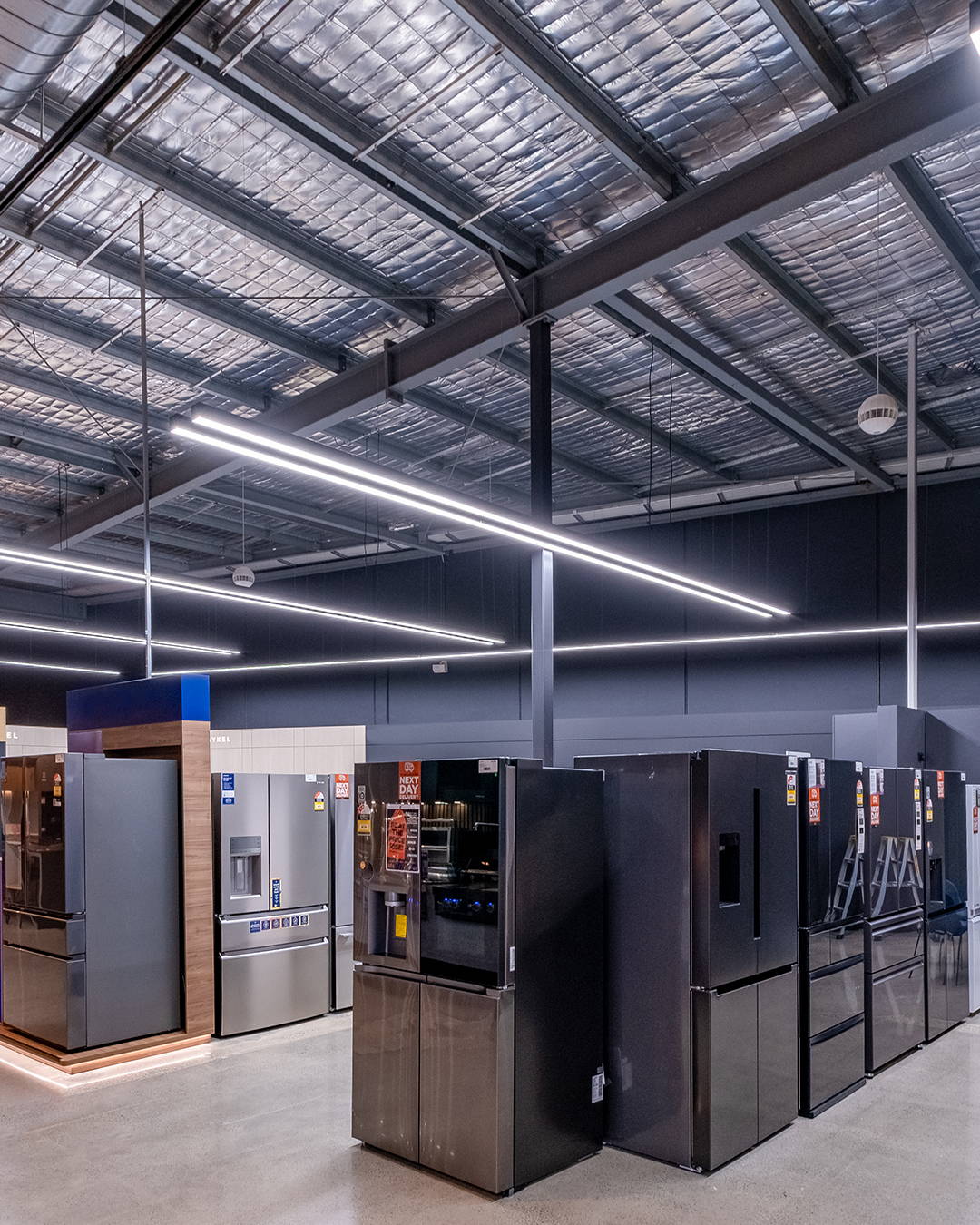 Black linear pendants installed throughout a commercial interior to add rhythm and consistency to the open layout.